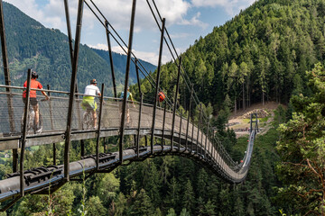 Radfahrer überqueren Hängebrücke Marterloch in den Südtiroler Alpen