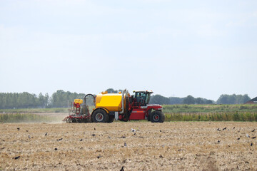 a hydro trike is fertilizing a bare field with slurry in the countryside in summer