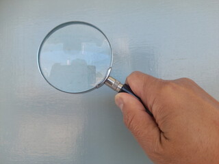 hand holding magnifying glass