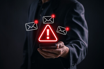 Phishing Email Alert Concept. Businessman holding smartphone with warning icon and email spam...