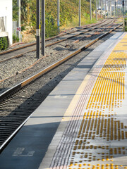 Close-up view of yellow tactile paving with raised blister bumps for visually impaired pedestrians,...