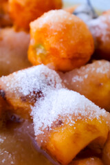 Fresh peach slices sprinkled with sugar, prepared for homemade jam making in a close-up view.