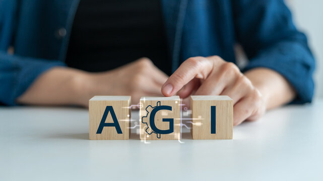 wooden blocks with letters AGI and digital gear icon, symbolizing Artificial General Intelligence, advanced AI technology, machine learning, automation, and future innovation in computer science.