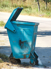 Large green garbage dumpster placed outdoors for waste collection and recycling purposes.