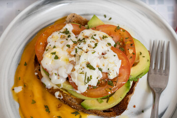 Delicious guacamole toast with fresh tomato and mozzarella