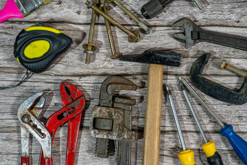 Handyman tools laying on rustic wooden background for home improvement projects