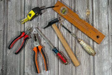 Assorted work tools lying on rustic wooden table