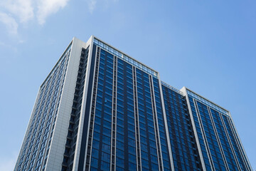 Low angle view of skyscraper with glass window and clear blue sky background for business and finance concept