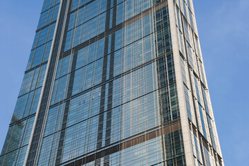Obraz premium Low angle view of skyscraper with glass window and clear blue sky background for business and finance concept