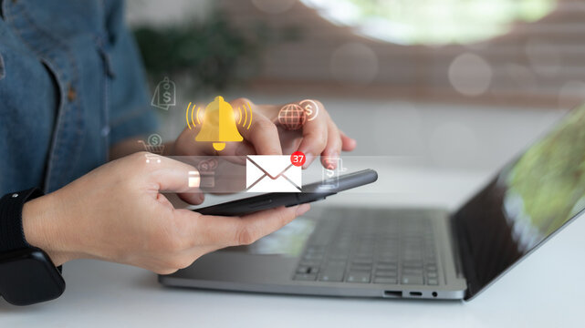 Close-up of hands using smartphone with email notification icon showing 37 new messages and bell alert symbol, representing online communication, business email marketing, and message reminder system.