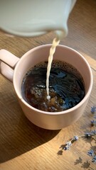 Cup of coffee with milk on a table in soft morning light. Cozy and calm atmosphere with warm tones and natural lighting.