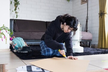 latina teenager cutting cardboard shapes for school