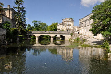 Jonzac in Charente, A serene scene of a stone bridge over the Seugne