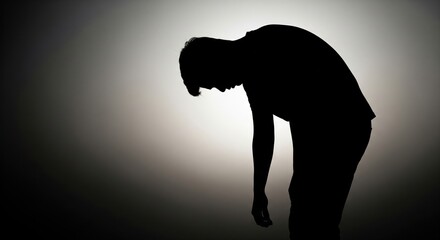 Silhouette of a Despondent Person with Head Down
