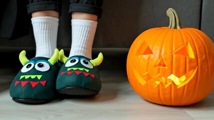 Person monster slippers feet pumpkin Halloween themed footwear cozy home comfort seasonal decoration