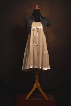 Cute mini dress in beige color with bolero jeans on a mannequin display