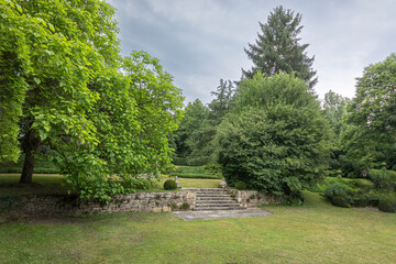 Lush garden with stone steps under cloudy sky