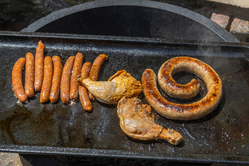 Grilling sausages and chicken outdoors