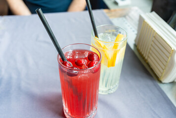 Cold lingonberry drink on restaurant table. Iced cowberry tea, refreshing cranberry cocktail