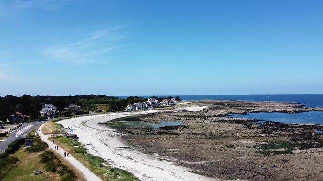 Aerial view of a coastal village with sandy beach and rocky shoreline. Beach and ocean idea. Travel and landscape concept.