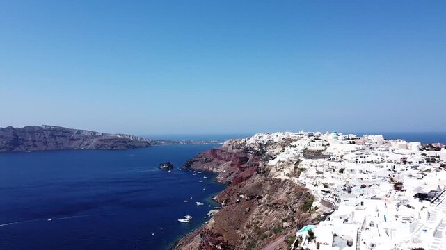 Aerial drone view of Santorini&rsquo;s whitewashed buildings overlooking the deep blue Aegean Sea. Island and coastal idea. Travel and landscape concept.