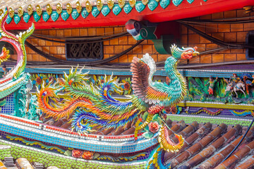 Obraz premium The roof of Taipei Mazu Temple, Taiwan, features intricate cut-and-paste ceramic sculptures. These colorful decorations depict dragons, phoenixes, flowers. 
