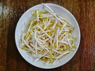 Fresh Bean Sprouts in White Plate on Rustic Wooden Table