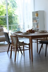 Beautiful table setting, chairs and decor in dining room. Interior design