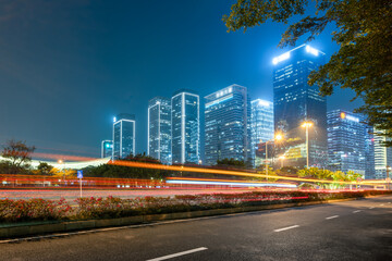 Night View of Modern City with Illuminated Skyscrapers and Light Trails