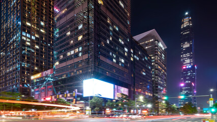 Night view of modern tall buildings with light trails in city