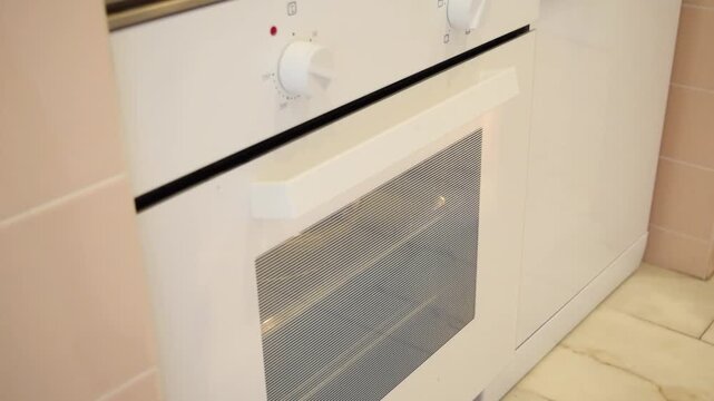 A person opens an oven and removes a hot dish using kitchen gloves. Cooking and meal idea. Home and kitchen concept.