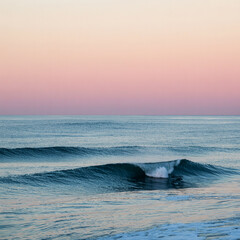 Fototapeta premium Calm ocean waves at sunset with pastel colored sky offering a peaceful seascape scene for relaxation and tranquility promoting mindfulness and serenity in nature