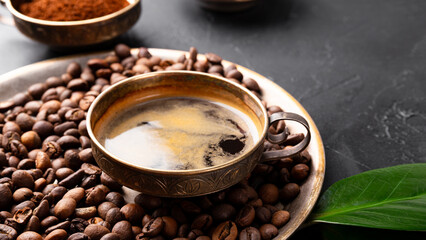 Coffee background - cup of black coffee, coffee beans on a black background, copy space for text