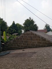 view of the roof of a house in a village decorated with trees