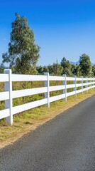 A white decorative fence features a lattice design, standing in front of golden autumn foliage and a clear blue sky in a peaceful residential neighborhood
