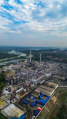 Aerial drone view of a large industrial factory complex with warehouses, chimneys, and storage tanks in Asia
