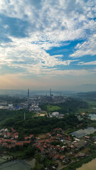 Aerial drone view of a large industrial factory complex with warehouses, chimneys, and storage tanks in Asia