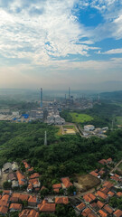 Fototapeta premium Aerial drone view of a large industrial factory complex with warehouses, chimneys, and storage tanks in Asia