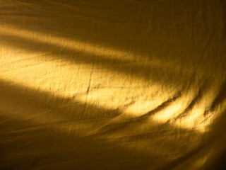 Golden light creating shadows on wrinkled fabric