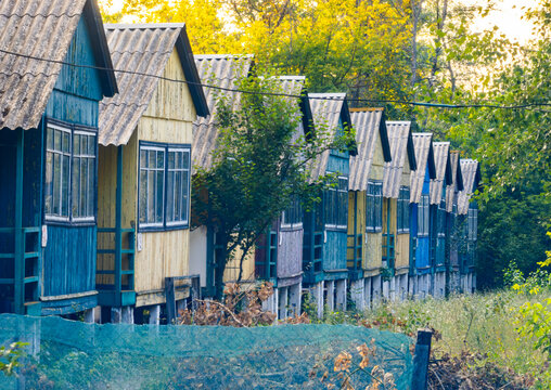 Row of colorful abandoned soviet-style wooden cabins in a summer camp