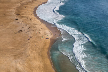 The surfers on Praia da Nazare, Portugal