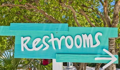 A tropical rest room sign painted in turquoise