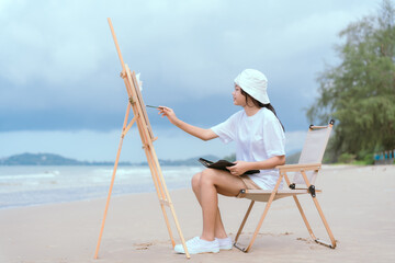 Naklejka premium Artist creates a vibrant landscape painting at the beach on a sunny day with gentle waves in the background