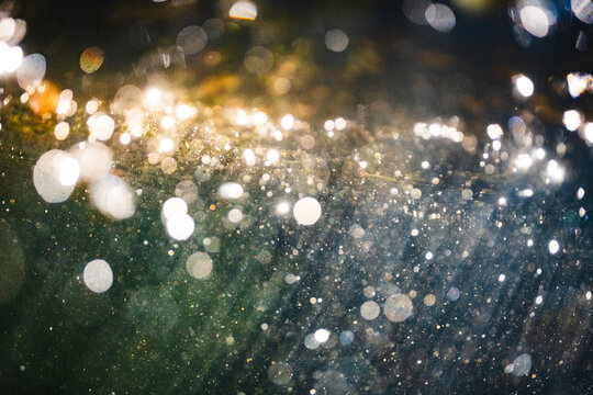 Sunlight streaming through water with abstract sparkling bubbles all around