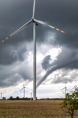 an electric windmill against the background of a developing tornado