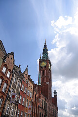 A view of the historical center of Gdansk, Poland, with medieval and 17th century houses and the green tower of the city hall with a clock. 
