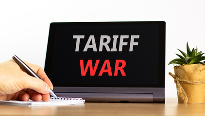 Trade tariff war symbol. Concept word Tariff war on beautiful black tablet. Businessman's hand with...