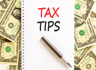 Tax tips symbol. Concept word Tax tips on beautiful white note. Dollar bills. Beautiful dollar...