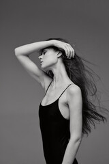 Black and white profile of a slender woman with flowing hair in a sleeveless top, expressing calm...