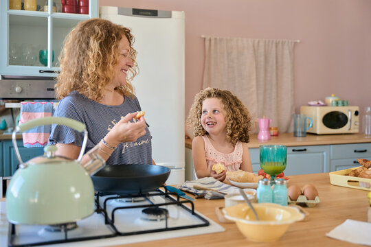 Mother and daughter sharing a moment while preparing breakfast in the kitchen